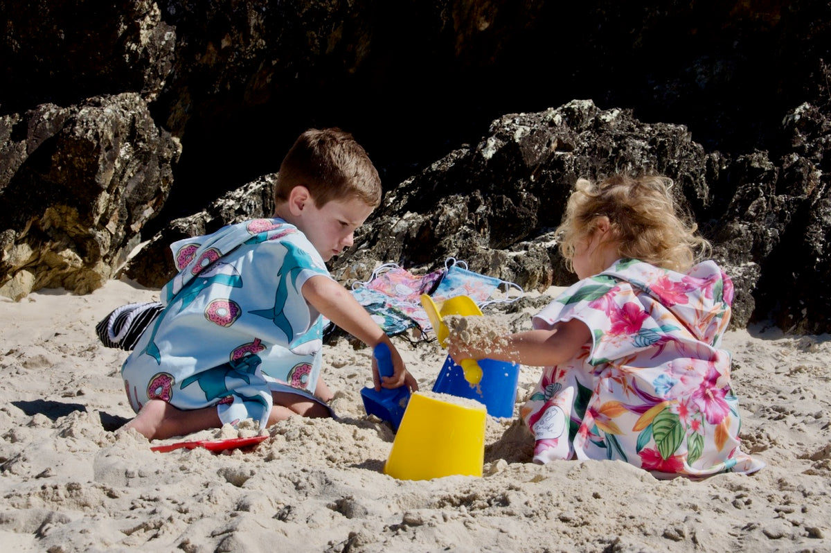 The perfect companion on the beach whilst playing with buckets and spaes here we see a boy and a girl one wearing feeding frenzy the other the island princess great for keeping warm after a southerly wind blows in