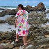 Island Princess Sand-Free Hoodie (One Size Fits All): Adult Female Exploring the Rocky Coastline. [Walking confidently on oceanfront rocks, turquoise water stretching into the distance.]