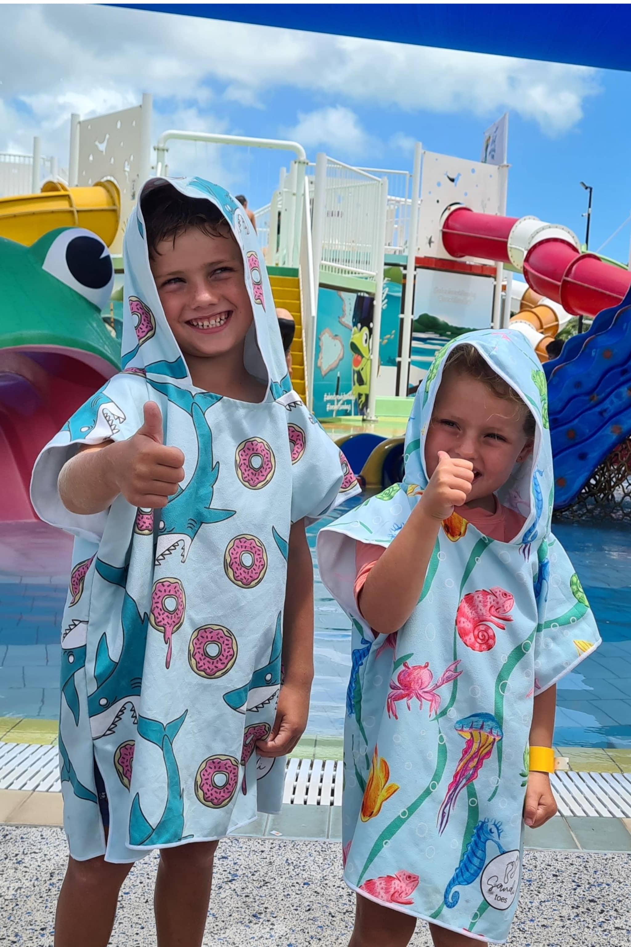 Having fun at the kids waterpark are two of our regular sandi toes young models in their feeding frenzy and earth and sea sand free hoodies