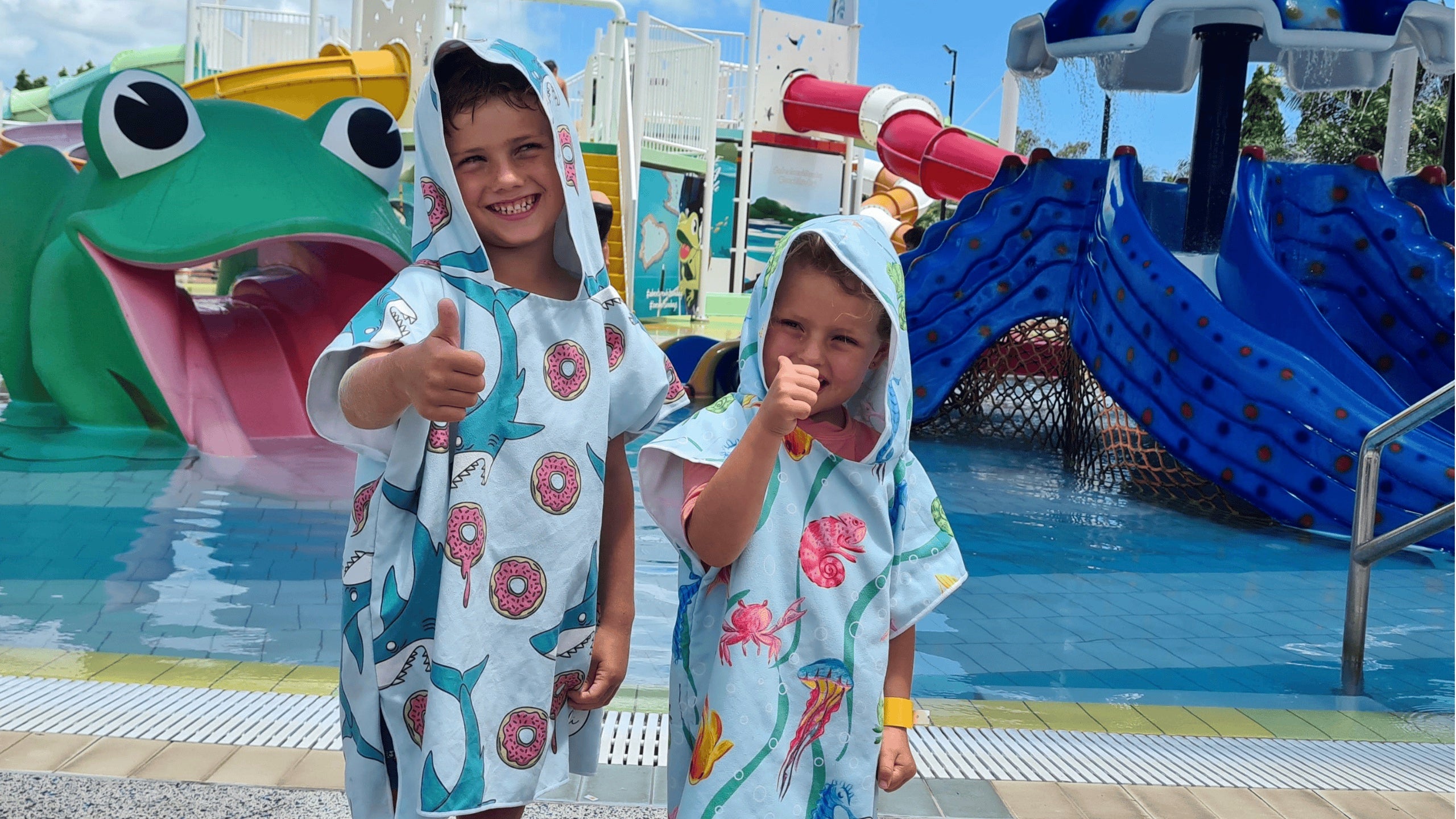 Having fun at the kids waterpark are two of our regular sandi toes young models in their feeding frenzy and earth and sea sand free hoodies